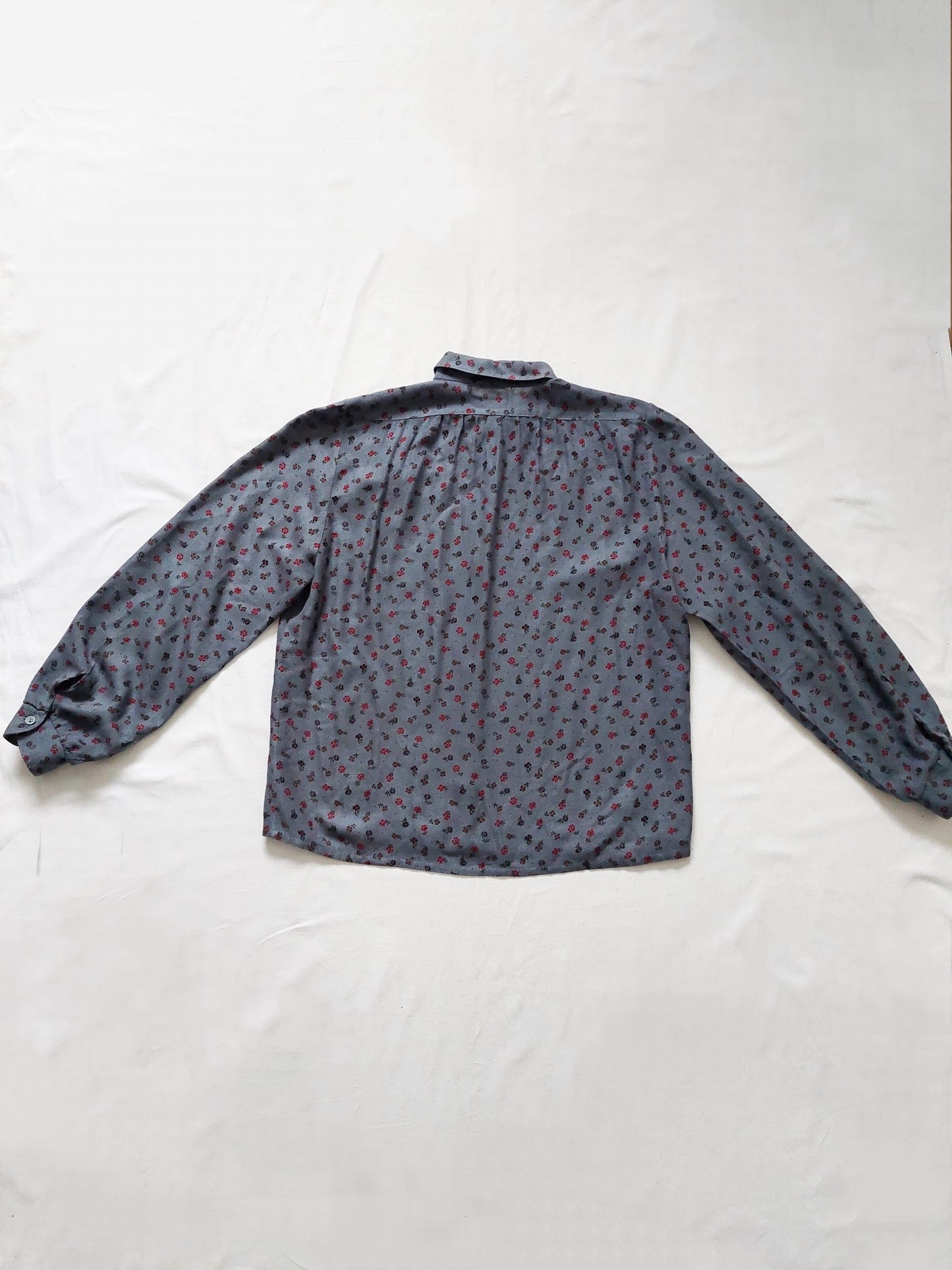 The back of the blue shirt with small flower details