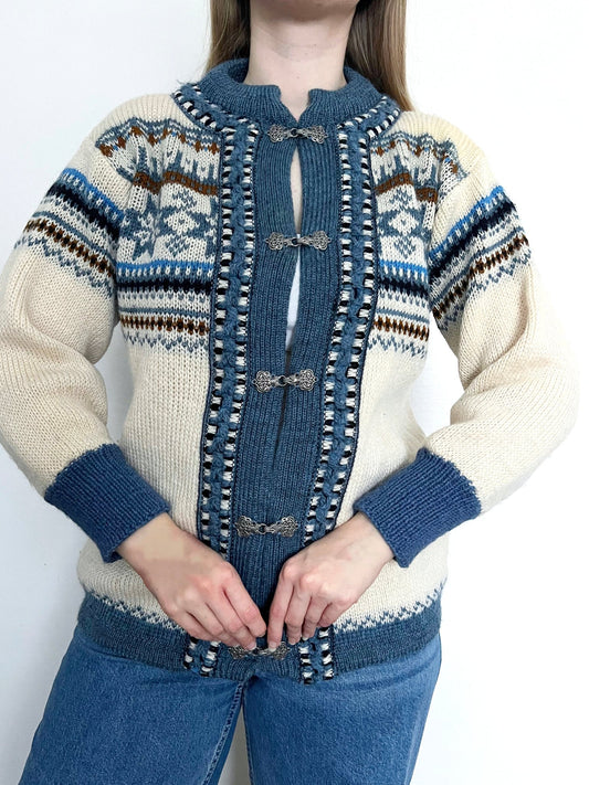 A wool cardigan in a classic Nordic/Norweigan pattern, mainly in blue and white. Made in Norway