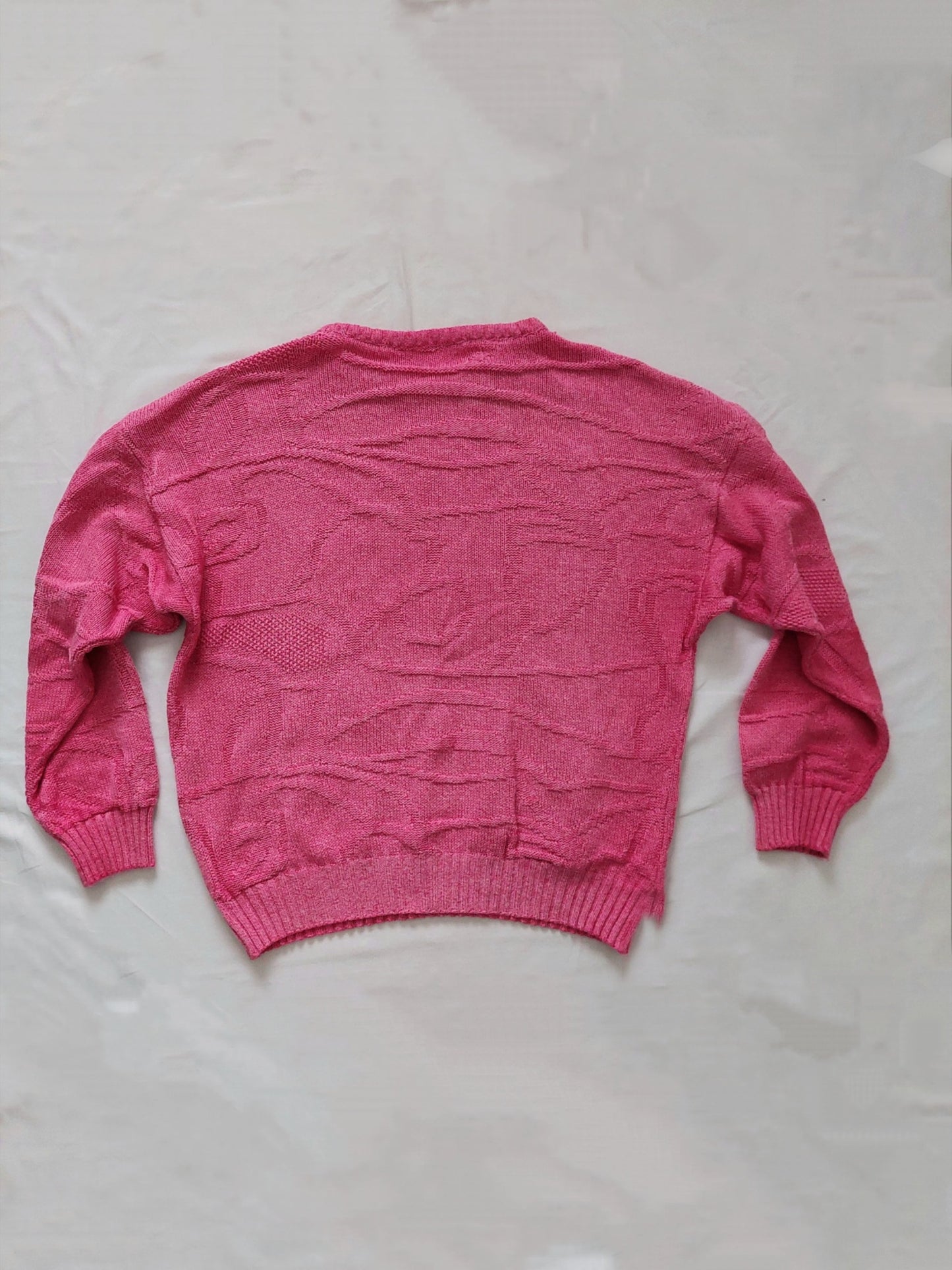 A pink knitted sweater with unique swirly pattern 