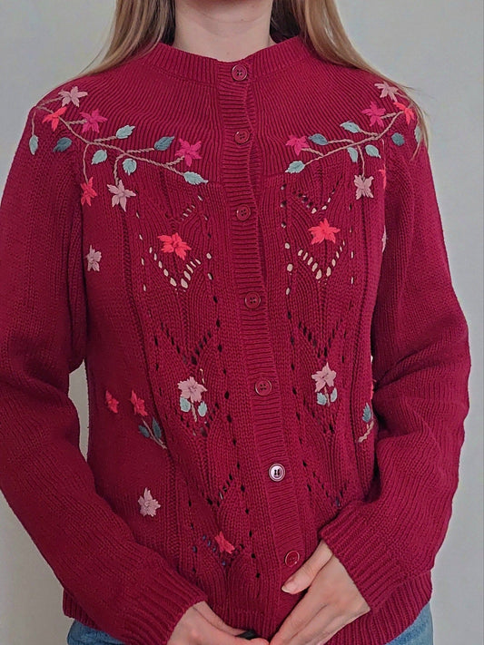 A person wearing the burgandy cardigan with flower details