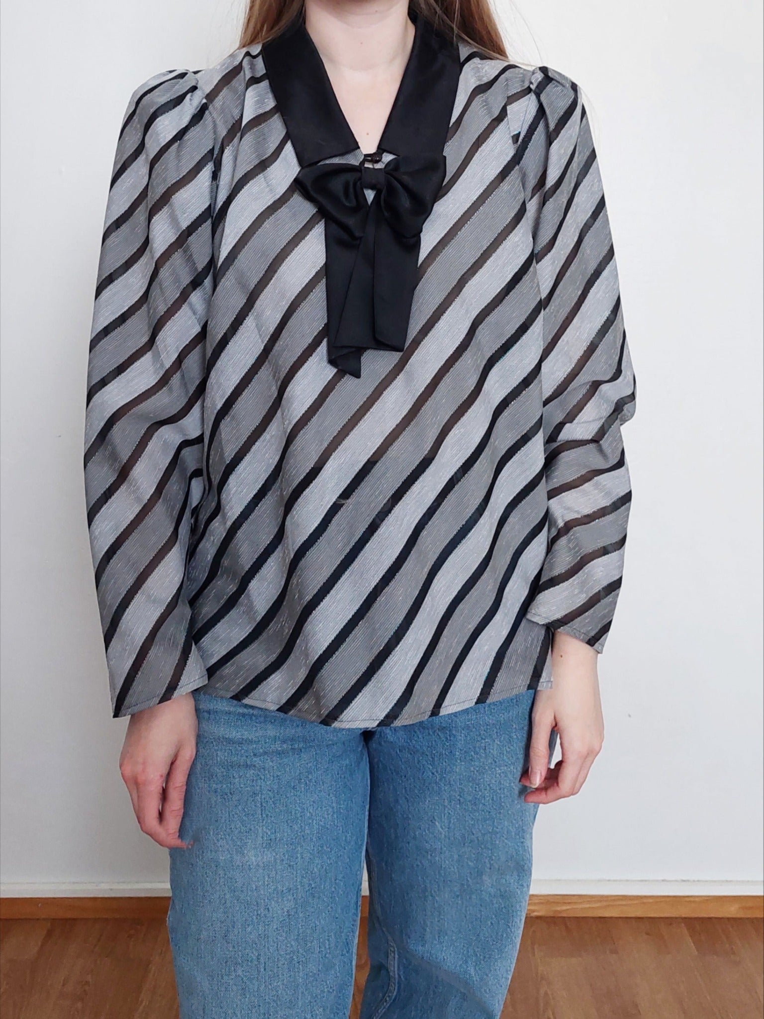 A person wearing the gray & black blouse with a bow