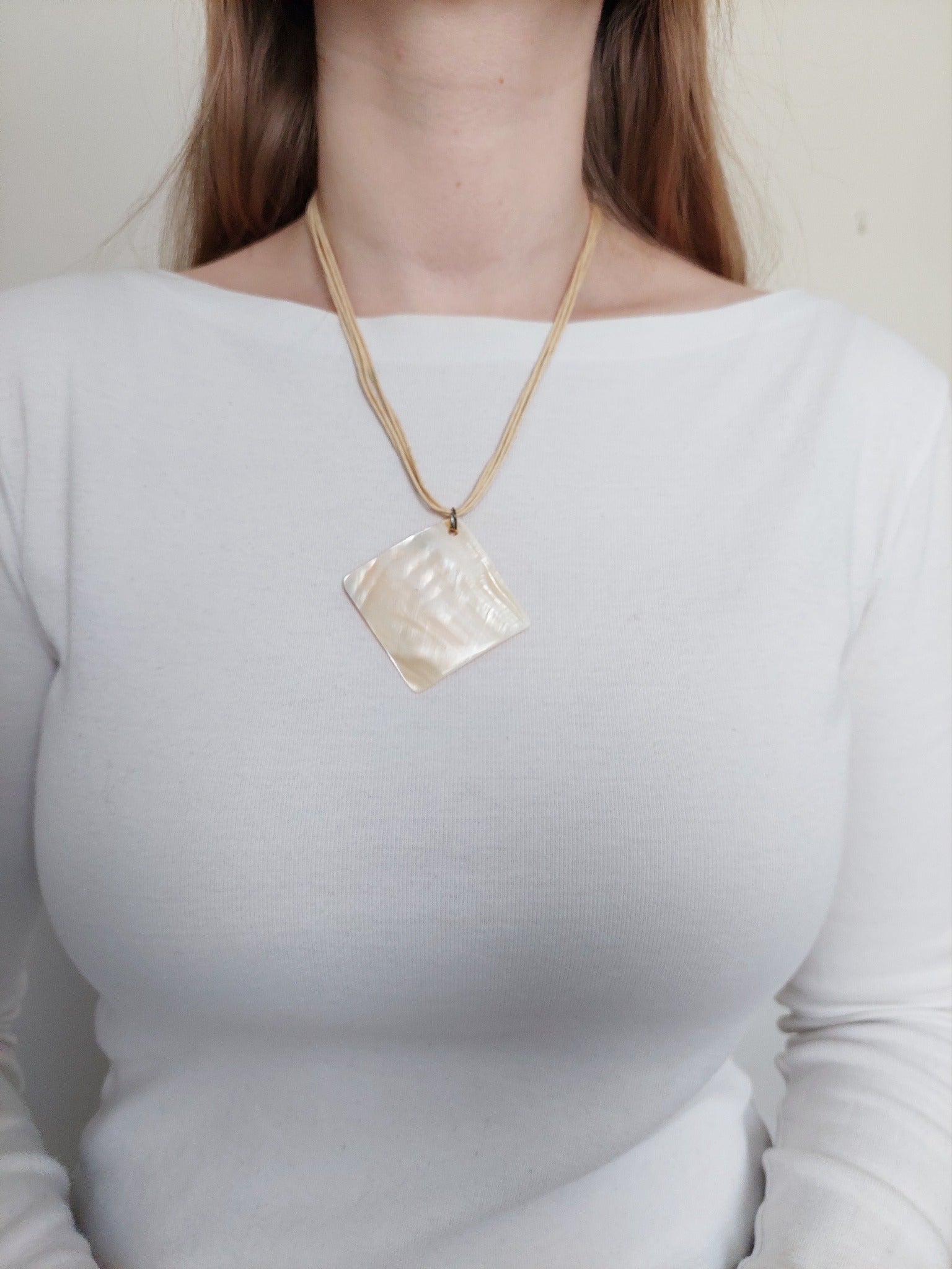 A person wearing the white stone necklace