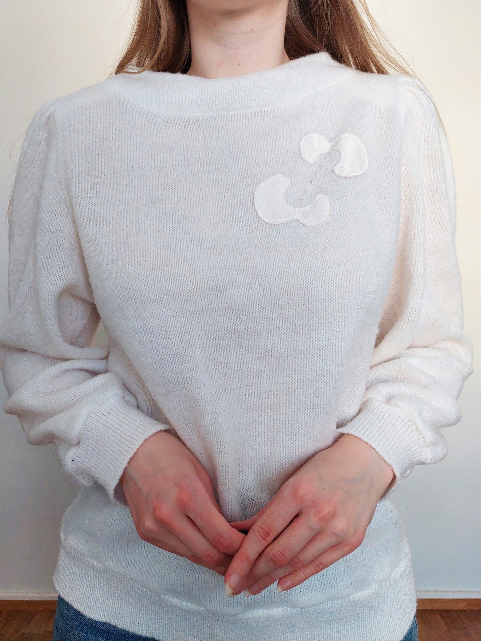 A person wearing the white sweater