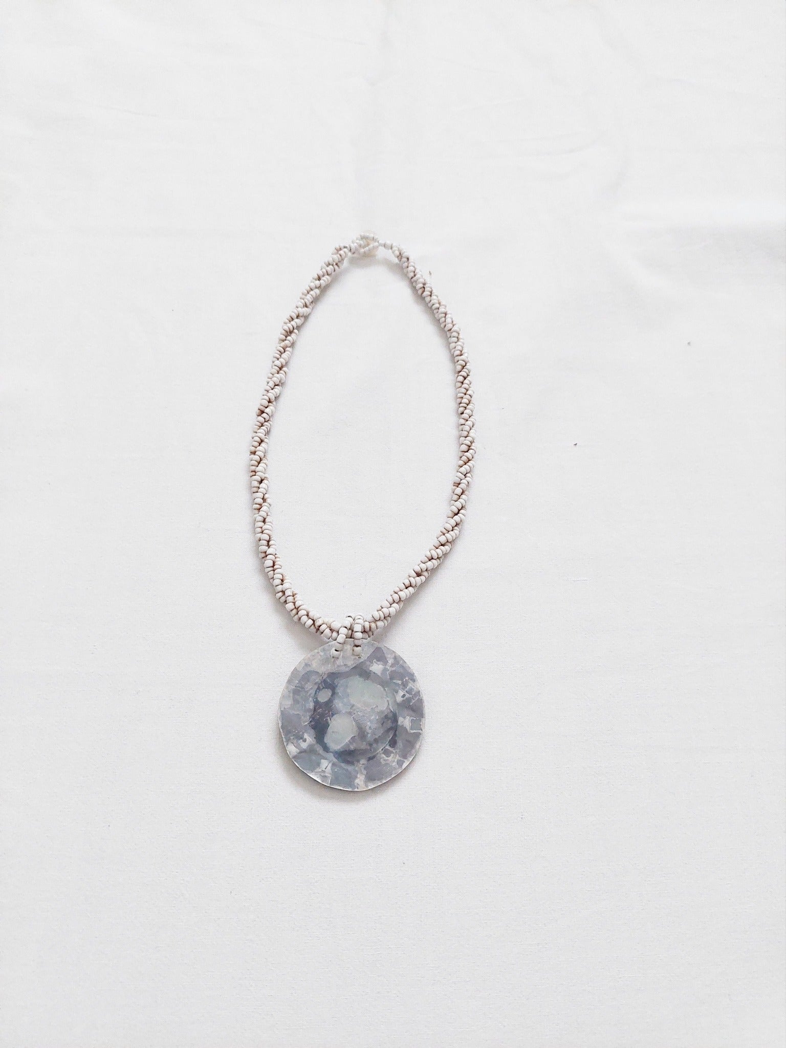 A necklace with a gray central piece