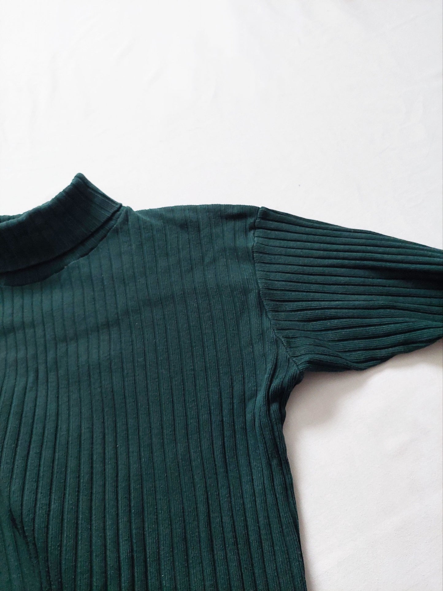 A close up of the green ribbed turtleneck