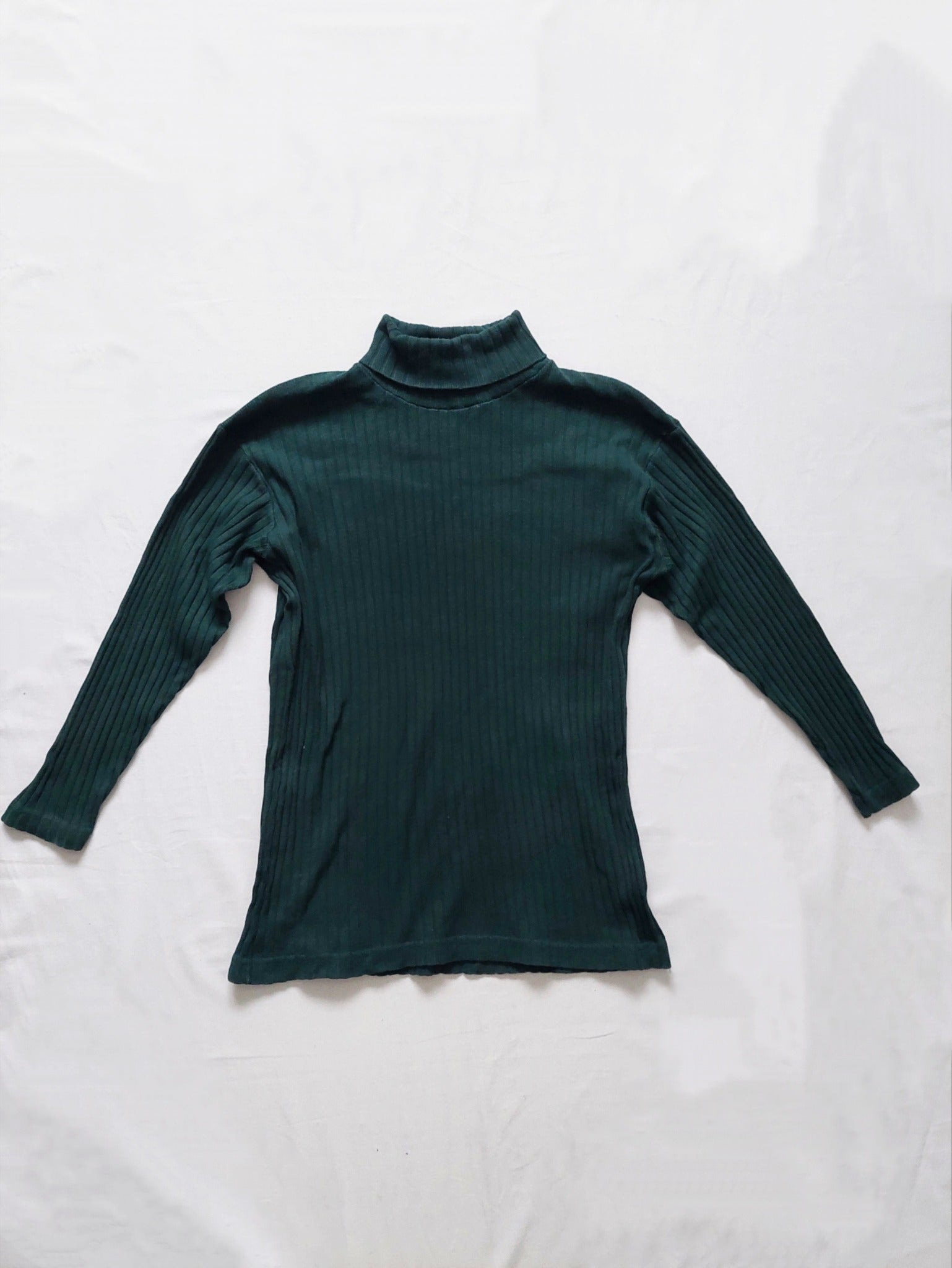 the back of the green ribbed turtleneck