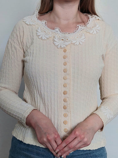 A person wearing the white cardigan with lace details